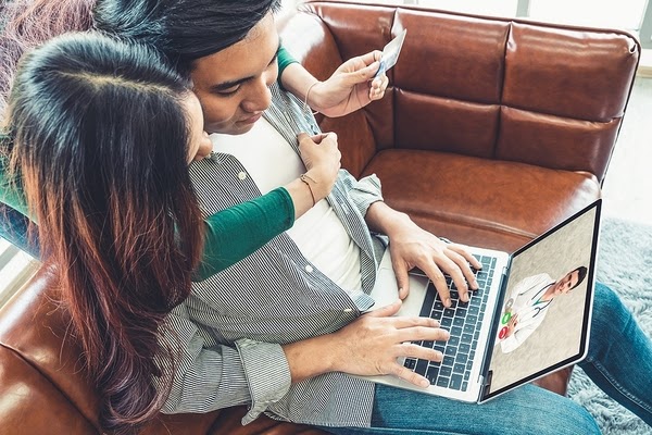 Couple looking at laptop considering healthcare Consolidation