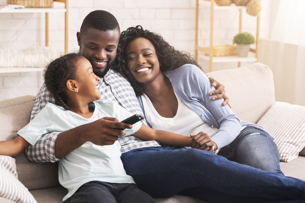 family smiling sitting together on couch