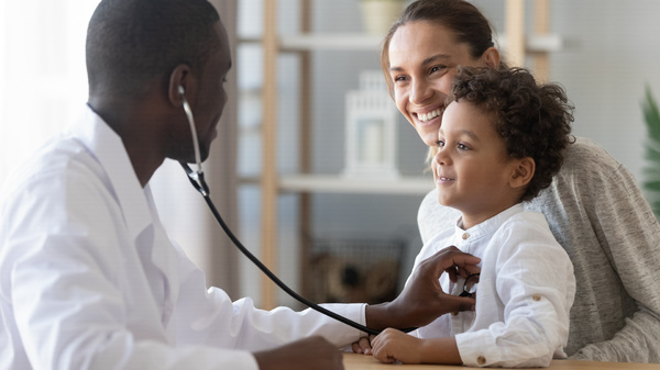 Doctor with stethoscope listening to toddler heart