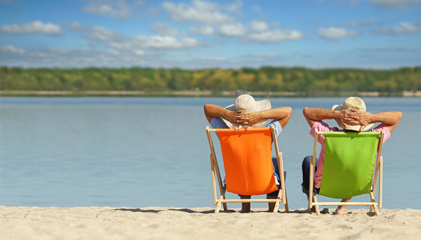 Two seniors sitting on beach chairs on the beach