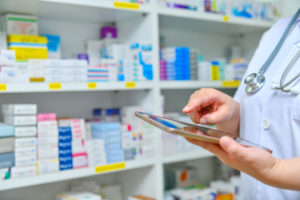 Person working in pharmacy with tablet